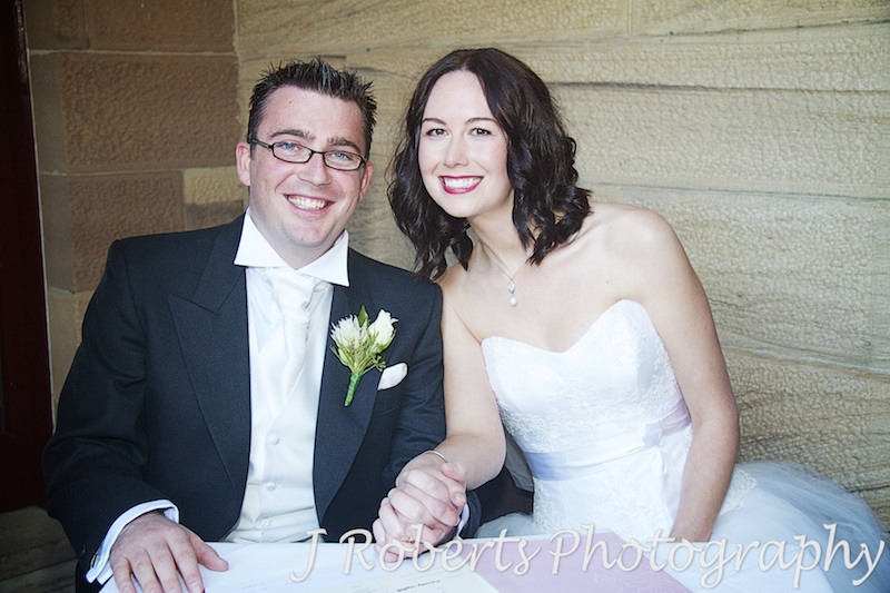 Signing the register all smiles - wedding photography sydney